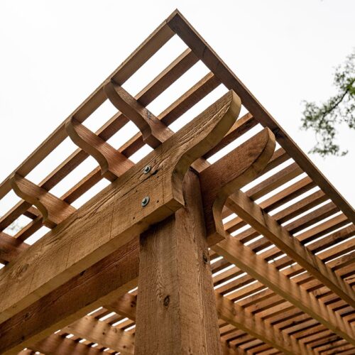 wood pergola Corner of pergola infrastructure focusing on bolts and screws that was built by The Pergola Shop